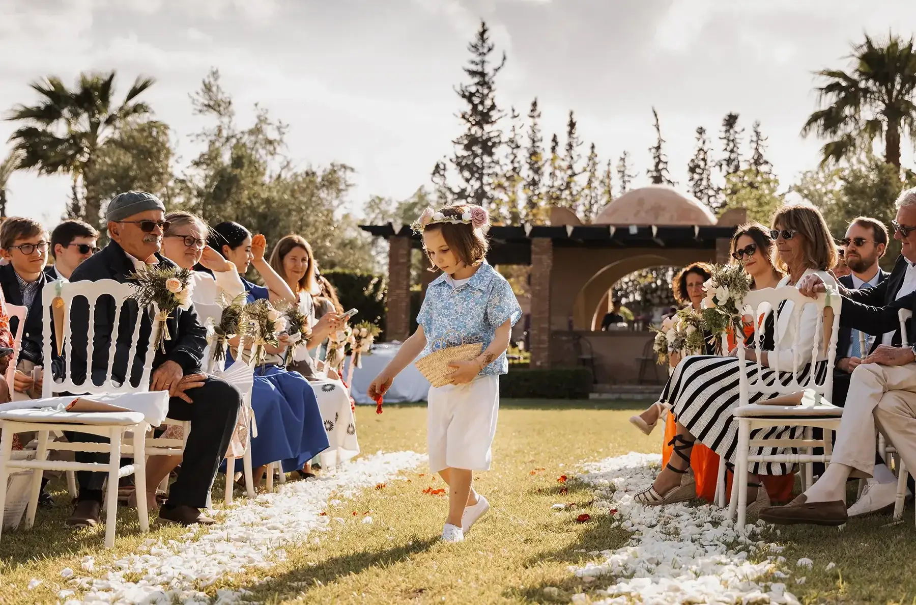 Enfant d’honneur dispersant des pétales dans l’allée d’une cérémonie de mariage à MarrakechFlower child scattering petals along the aisle during a wedding ceremony in Marrakech