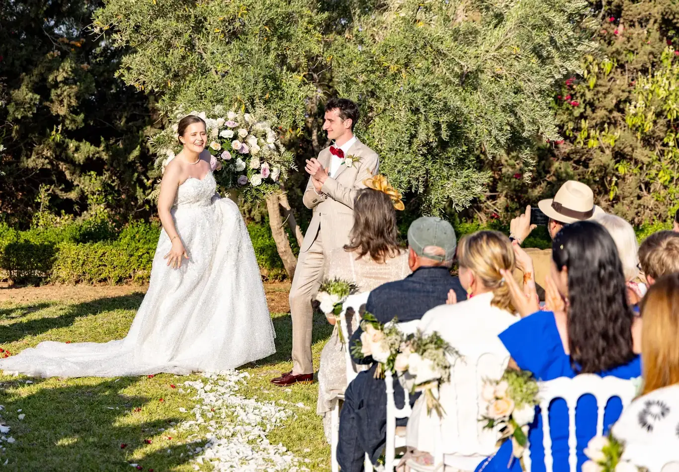 Mariés souriant devant leurs invités pendant une cérémonie dans un jardin à MarrakechSmiling newlyweds in front of their guests during a garden ceremony in Marrakech