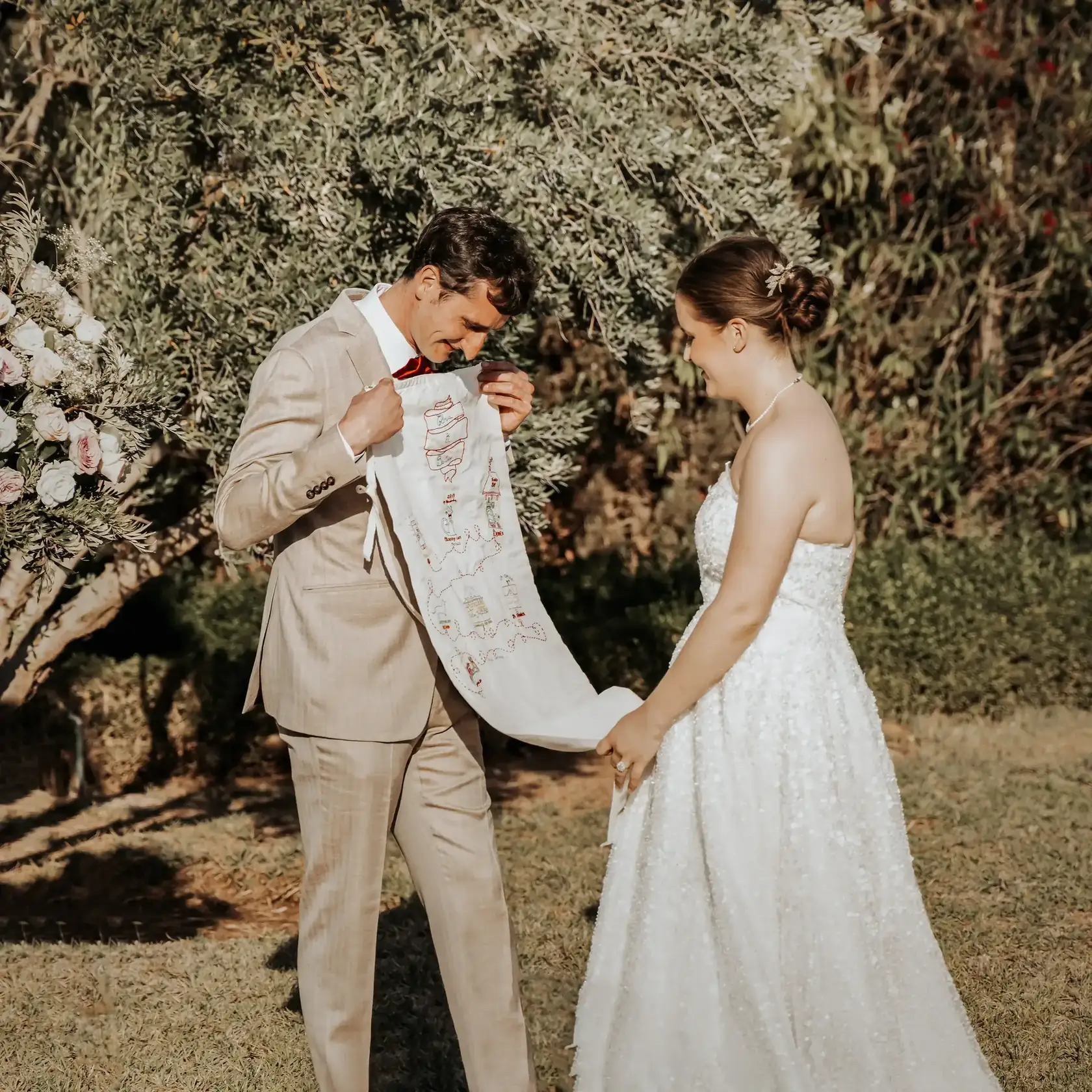 (ALT)Mariés présentant une étoffe brodée pendant un rituel symbolique dans un jardin à MarrakechNewlyweds holding an embroidered cloth during a symbolic garden wedding ritual in Marrakech