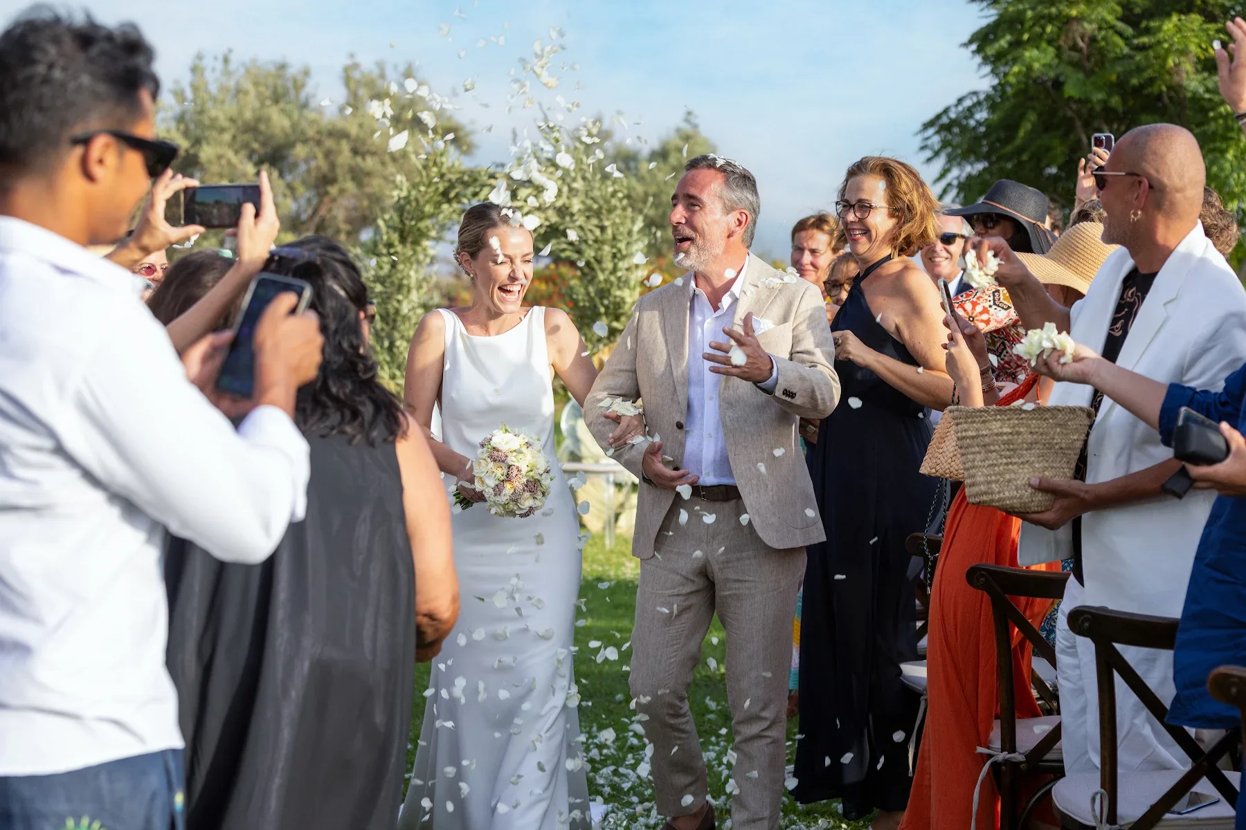 Mariée accompagnée dans l’allée sous une pluie de pétales à MarrakechBride walking down the aisle with her escort beneath a shower of petals in Marrakech